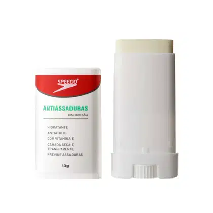 A embalagem é branca e vermelha, com o nome do produto "Antiassaduras" destacado em verde. O produto é descrito como hidratante, antiatrito, com vitamina E, para pele seca e transparente, além de prevenir assaduras. O tamanho do produto é de 13g.