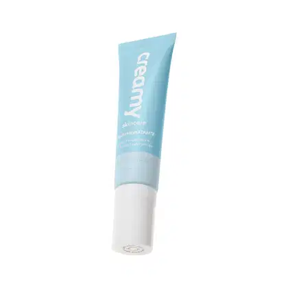 Tubo de creme hidratante da marca Creamy, com embalagem azul clara e texto branco indicando "Creamy skincare". O produto possui textura cremosa e aparência suave.
