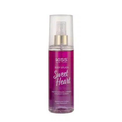 A imagem mostra o Body Splash em uma embalagem com cores roxo, rosa e dourado, apresentando o logotipo Kiss New York. A tampa é transparente e traz um detalhe dourado na válvula spray.