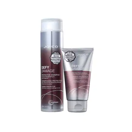 A imagem mostra dois produtos da linha Defy Damage da marca Joico: shampoo de 300ml e máscara de 150ml. As cores predominantes são roxo, branco e prata.