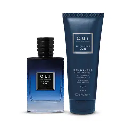 A imagem mostra um frasco de vidro azul escuro com a tampa preta com um eau de parfum da linha "Le Flaneur 020". Ao lado direito, há um tubo cilíndrico azul marinho com gel de banho. Os produtos têm um design elegante e sofisticado.