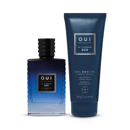 Frascos do perfume e gel de banho O.U.i Le Flâneur 020. Perfume à esquerda, em frasco de vidro azul escuro com detalhes pretos na tampa. O gel de banho, à direita, é embalado em um tubo plástico azul marinho com escrita em prata onde se lê gel douche.