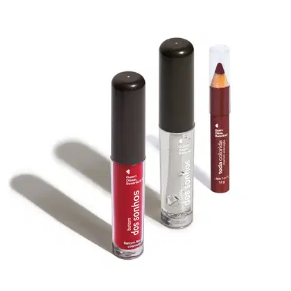 Frasco transparente com líquido vermelho e tampa preta de Batom dos Sonhos, frasco transparente com líquido claro e tampa preta de gloss labial incolor Batom dos Sonhos e lápis 3 em 1 Toda Colorida Marrom Animação, todos da marca Quem Disse, Berenice?