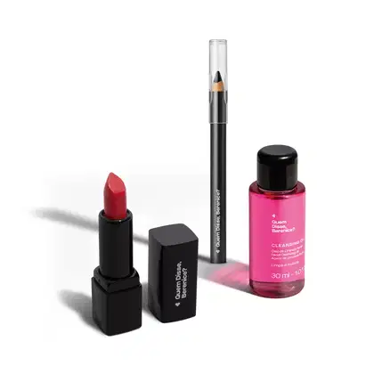 Batom de cor vermelha em embalagem preta com letras brancas, lápis de olhos preto com corpo da mesma cor e um óleo de limpeza facial em embalagem transparente com líquido rosa e tampa preta da marca Quem Disse, Berenice?.