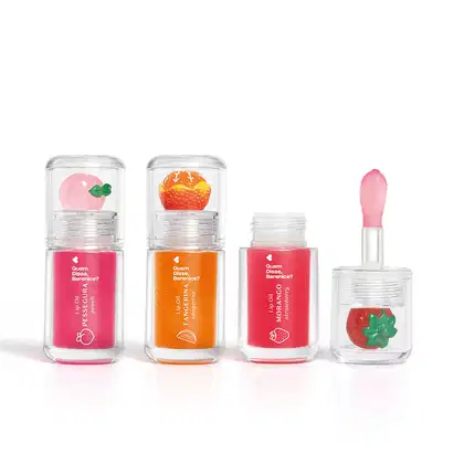 Imagem do Combo Lip Oil Quem Disse, Berenice? com as cores Vermelho Morango, Rosa Fúcsia Pessegura e Coral Tangerina. As embalagens são transparentes com aplicador macio e trazem a fruta correspondente decorando a tampa.