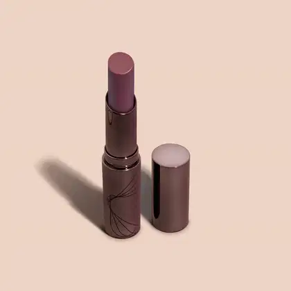 Batom semi matte de cor vinho escuro em embalagem cilíndrica marrom escura com detalhes pretos da marca Volumão Vinho Castanhelê Quem Disse, Berenice? em fundo lilás.