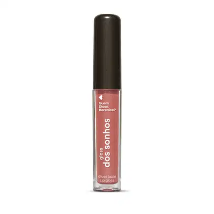 A imagem mostra um gloss labial em uma embalagem cilíndrica com a tampa preta e o tubo transparente permite ver o tom nude rosado brilhante do gloss e a marca Quem disse, Berenice? e a linha estampados no frasco.