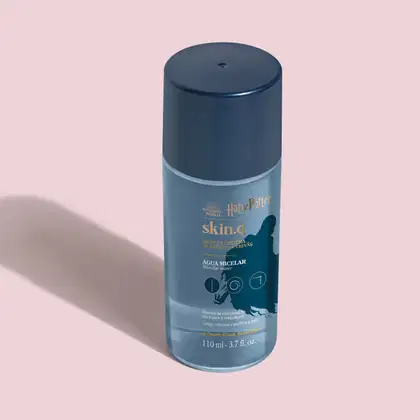 O frasco contém um produto líquido chamado "Skin.q Água Micelar" da linha Harry Potter. A embalagem apresenta detalhes em tons de azul claro e branco, incluindo o logotipo da marca Harry Potter, o nome do produto "Defesa Contra a Arte das Trevas."