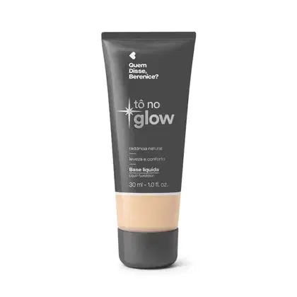 Bisnaga cinza de base líquida da marca Tô no Glow Quem disse, Berenice?, com detalhe na cor da base na parte inferior da embalagem e texto branco branco no rótulo.