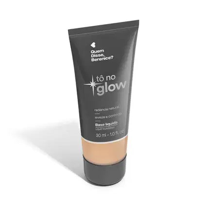 O produto apresentado é uma base líquida da marca Tô no Glow, com embalagem em tubo plástico de cor cinza escura. O rótulo exibe o nome da marca e o texto "Radiância natural, leveza e conforto" em letras brancas.
