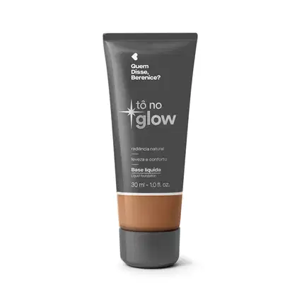 Bisnaga cinza de base líquida da marca Tô no Glow Quem disse, Berenice?, com detalhe na cor da base na parte inferior da embalagem e texto branco branco no rótulo.
