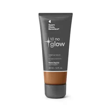Bisnaga cinza de base líquida da marca Tô no Glow Quem disse, Berenice?, com detalhe na cor da base na parte inferior da embalagem e texto branco branco no rótulo.