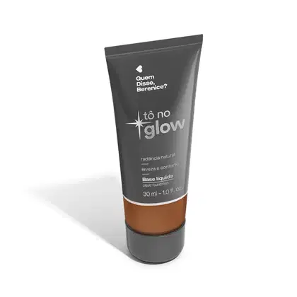 O produto apresentado é uma base líquida da marca Tô no Glow, com embalagem em tubo plástico de cor cinza escura. O rótulo exibe o nome da marca e o texto "Radiância natural, leveza e conforto" em letras brancas.