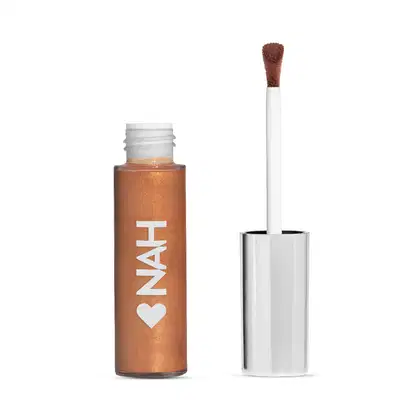 Frasco de item de make com aplicador em formato de pincel, na cor bronze com texto branco "NAH" e coração, sobre fundo branco.