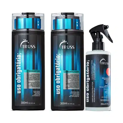 A imagem mostra três produtos da linha Uso Obrigatório da marca TRUSS. Shampoo e condicionador de 300ml e tratamento reconstrutor de 260ml. As cores predominantes são preto e azul.