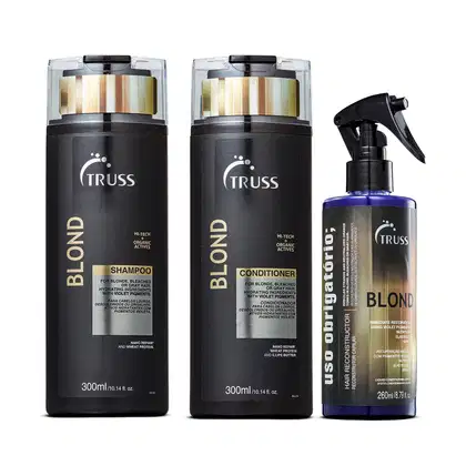 A imagem mostra produtos da marca TRUSS. Dois frascos pretos de 300ml contêm shampoo e condicionador da linha Blond, com detalhes em dourado e violeta. O terceiro produto é um spray de 260ml "Uso Obrigatório Blond" em uma embalagem preta e violeta.