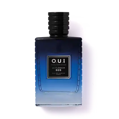 A imagem mostra um frasco azul escuro de eau de parfum da marca O.U.i. O frasco tem um formato retangular com detalhes em alto relevo, dando-lhe uma aparência sofisticada. Na parte frontal, há um rótulo preto com o nome da marca e do Eau de Parfum.
