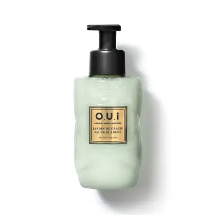 Frasco tipo pump de sabonete líquido da marca O.U.i. com rótulo em fundo verde-claro e detalhes dourados, contendo a descrição "Jardin de Grasse Sauge Blanche" (Jardim de Grama Branca).