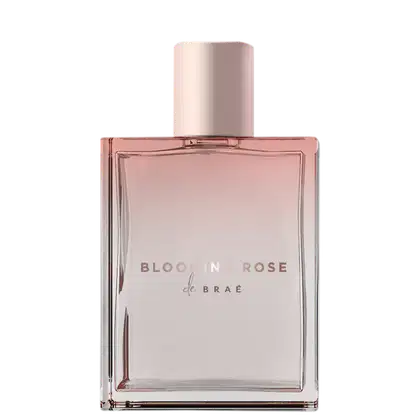 Frasco de perfume capilar Blooming Rose da marca Braé, com design elegante e minimalista em tons de rosa e branco. O rótulo destaca o nome do produto em letras douradas.