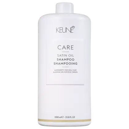 Frasco branco de 1000 ml da linha Care da Keune, contendo Shampoo de Óleo Satin. O rótulo destaca a luminosidade para cabelos opacos.