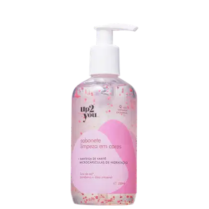Embalagem plástica transparente com líquido rosa claro e detalhes em forma de corações cor-de-rosa espalhados. Bomba dosadora branca no topo. Rótulo rosa com texto descrevendo o produto. Capacidade de 250ml.