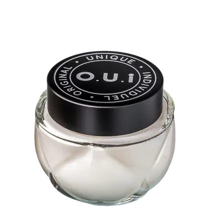 Frasco de vidro transparente com tampa preta redonda contendo produto da marca O.U.i. O rótulo preto destaca o nome da marca e a declaração "Unique Original Indulgent" em letras brancas.