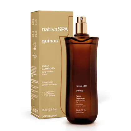 Vidro alongado marrom com pulverizador dourado e letras brancas contendo óleo multifuncional glorioso corpo e cabelos da marca Nativa SPA Quinoa ao lado de sua caixa em bege escuro com letras brancas.