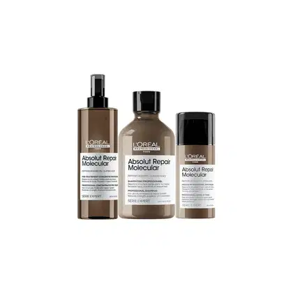 Três produtos da linha Absolut Repair Molecular da L'Oréal Professionnel: um frasco spray, um frasco de shampoo e um tubo de tratamento, todos em embalagens pretas e bege com rótulos destacando os benefícios da fórmula.