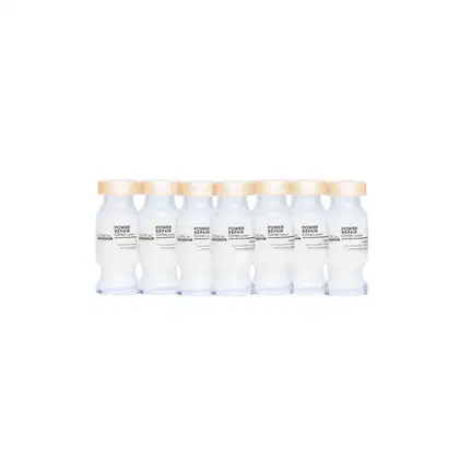 Frascos brancos da linha Power Repair da L'Oréal Professionnel, com tampas douradas, exibindo o nome do produto em destaque. Os frascos estão alinhados em uma fileira, sugerindo uma apresentação de produtos de cuidados capilares.