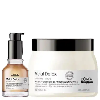 O produto de beleza apresentado é um conjunto da linha Metal Detox da L'Oréal Professionnel, composto por um frasco de óleo concentrado e uma embalagem de máscara profissional, ambos com design moderno e predominância de cores preto e branco.