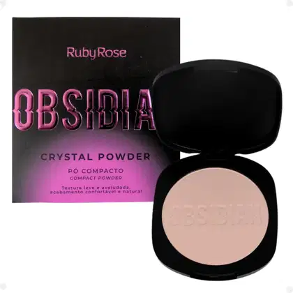 Pó compacto de Ruby Rose. A embalagem consiste em uma caixa preta com o nome do produto em letras rosa brilhante e um estojo preto contendo o pó de cor bege claro. O estojo tem o nome "Obsidia" gravado na superfície do pó.