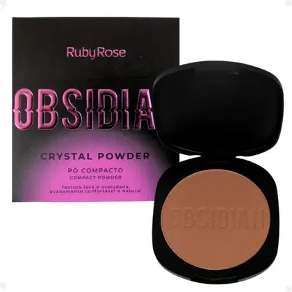 Pó compacto de Ruby Rose. A embalagem consiste em uma caixa preta com o nome do produto em letras rosa brilhante e um estojo preto contendo o pó de cor bege claro. O estojo tem o nome "Obsidia" gravado na superfície do pó.