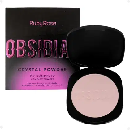 Pó compacto de Ruby Rose. A embalagem consiste em uma caixa preta com o nome do produto em letras rosa brilhante e um estojo preto contendo o pó de cor bege claro. O estojo tem o nome "Obsidia" gravado na superfície do pó.