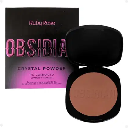 Pó compacto de Ruby Rose. A embalagem consiste em uma caixa preta com o nome do produto em letras rosa brilhante e um estojo preto contendo o pó de cor bege claro. O estojo tem o nome "Obsidia" gravado na superfície do pó.