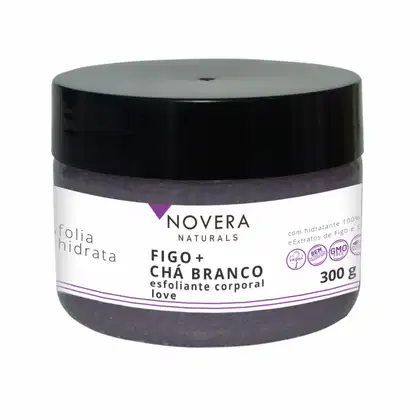 A imagem mostra um produto da linha Novera Naturals. É um esfoliante corporal chamado "Figo + Chá Branco". O frasco de 300g é preto com detalhes em branco e roxo. Nas informações do rótulo, destaca-se que é um produto 100% vegano.