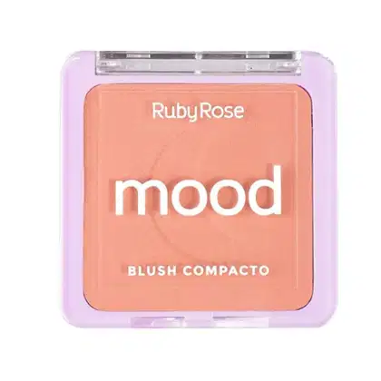 Blush compacto da marca Ruby Rose, com a palavra "mood" destacada em grande texto na embalagem. A embalagem é de plástico transparente com uma cor de fundo rosa claro. O blush em si possui uma tonalidade laranja-rosada.