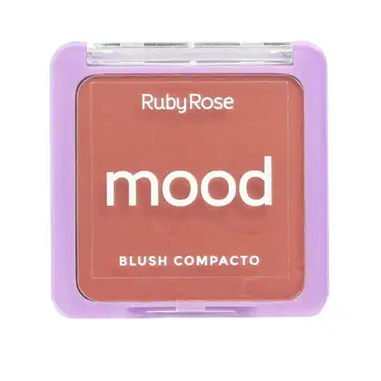 Blush compacto da marca Ruby Rose, com a palavra "mood" impressa na embalagem. A embalagem é retangular, com uma tampa transparente que permite visualizar o conteúdo. A cor predominante da embalagem é um tom de roxo claro.
