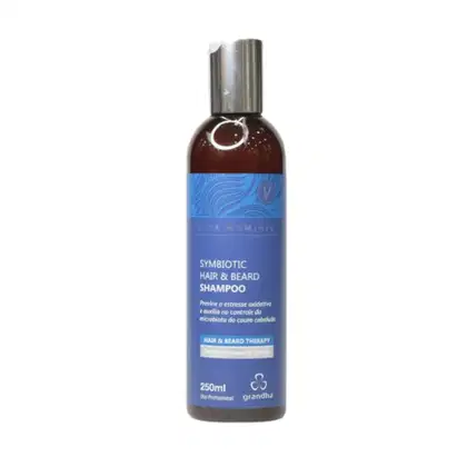 Frasco de 250ml de shampoo para cabelo e barba da marca Grandha, com design azul e marrom, rótulo indicando "Symbiotic Hair & Beard Shampoo" e informações sobre a terapia capilar.