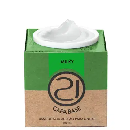 A imagem mostra uma base de alta adesão para unhas. O produto vem em uma embalagem retangular de papelão verde e marrom. No centro, há um recipiente branco contendo o produto, que parece ser um gel .em tom branco.