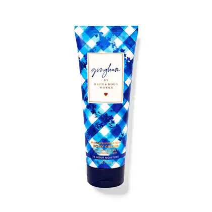 Tubo de creme corporal da Bath & Body Works com design de xadrez azul e branco, rótulo com nome da marca "Gingham" e informações sobre o produto.