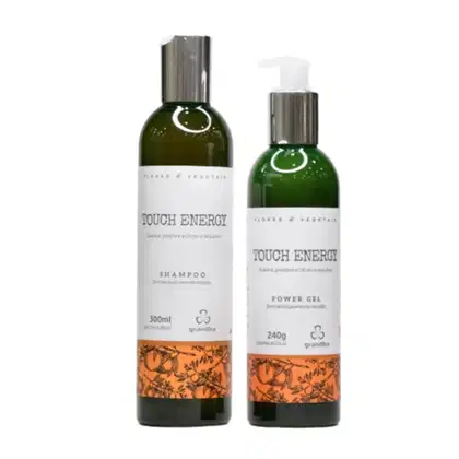 Produtos de beleza da marca Grandha, incluindo um frasco de shampoo e um tubo de gel, ambos com embalagens verdes e detalhes em laranja, exibindo o nome "Touch Energy" em destaque.