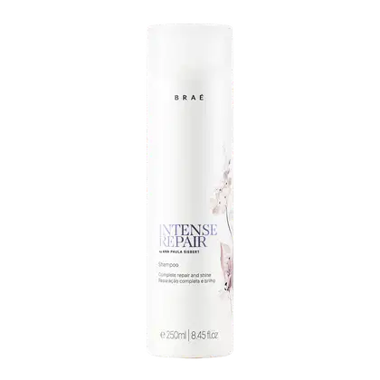 Frasco branco de shampoo da linha Intense Repair da marca Braé, com texto em preto e detalhes florais em tons de rosa. O produto é descrito como um tratamento completo de reparação e brilho para os cabelos.