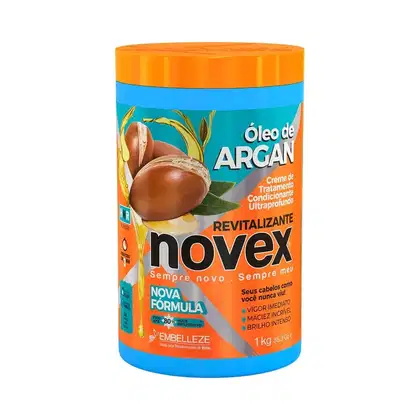 A imagem mostra o Creme de Tratamento Óleo de Argan 1kg da marca Novex. É um pote plástico cilíndrico na cor azul com tampa laranja. O rótulo destaca que o produto oferece restauração, brilho e nutrição profunda.