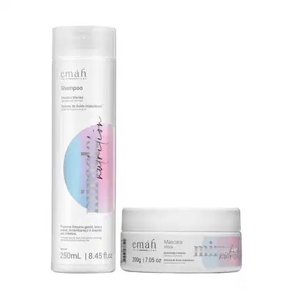 O conjunto de produtos Emáh Hair Care inclui um frasco de shampoo branco com rótulo rosa e azul, e um pote de máscara branco com rótulo semelhante. Ambos os produtos apresentam o sistema de ácido hialurônico como destaque em seus rótulos.