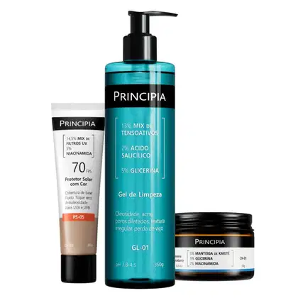 Três produtos da marca Principia: um protetor solar em tubo, um gel de limpeza em frasco com bomba e um creme hidratante em pote. As embalagens apresentam cores predominantes de preto e azul-turquesa.