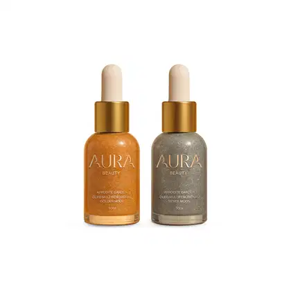 Dois frascos de óleo multifenomenal da marca Aura Beauty, um com tom dourado e outro com tom prateado, ambos com conta-gotas e rótulos dourados.