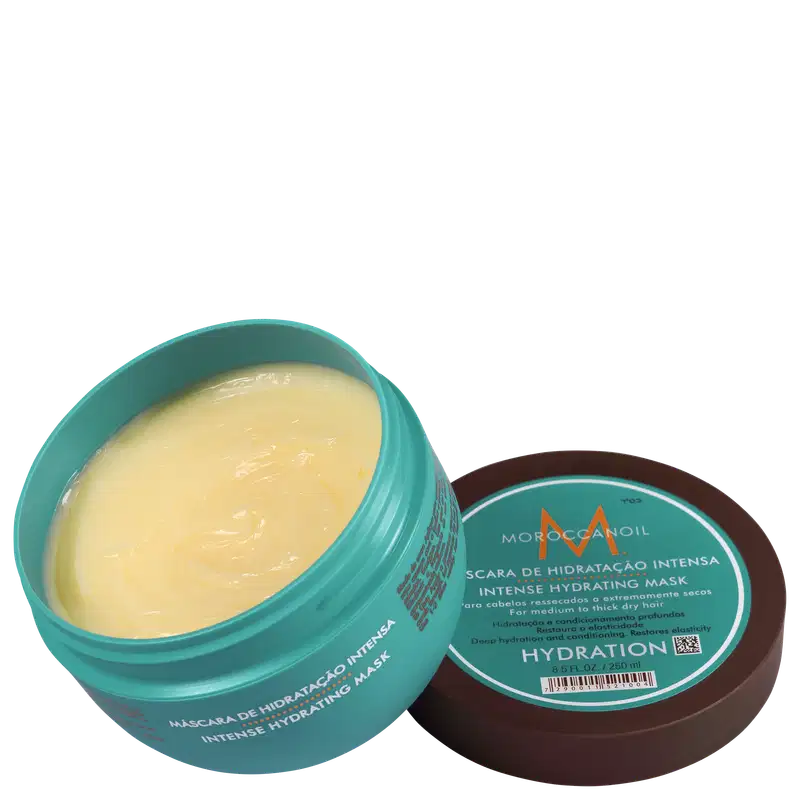 A imagem mostra a Máscara Capilar Moroccanoil Intense Hydration 250ml em um pote redondo na cor turquesa e uma tampa marrom ao lado. O pote está aberto e mostra a textura cremosa do produto.