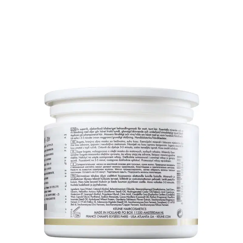 Frasco branco de produto de beleza da marca Keune, com rótulo informativo sobre os ingredientes e instruções de uso. O recipiente possui uma tampa arredondada e a embalagem apresenta o nome da marca e informações de contato.