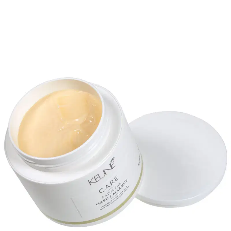 Recipiente branco de creme hidratante da marca Keune, com textura cremosa e brilhante, em um ambiente limpo e minimalista, sugerindo um produto de cuidados com a pele.