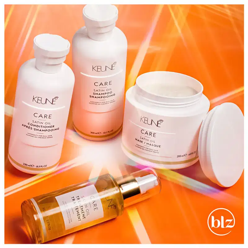 Produtos de cuidados capilares da marca Keune em um ambiente vibrante de cores quentes, incluindo shampoo, condicionador e máscara de tratamento, sugerindo um contexto de cuidados com a beleza e saúde dos cabelos.